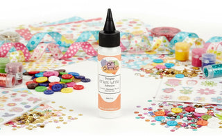 Bottle of glitter glue on a table with colorful craft supplies