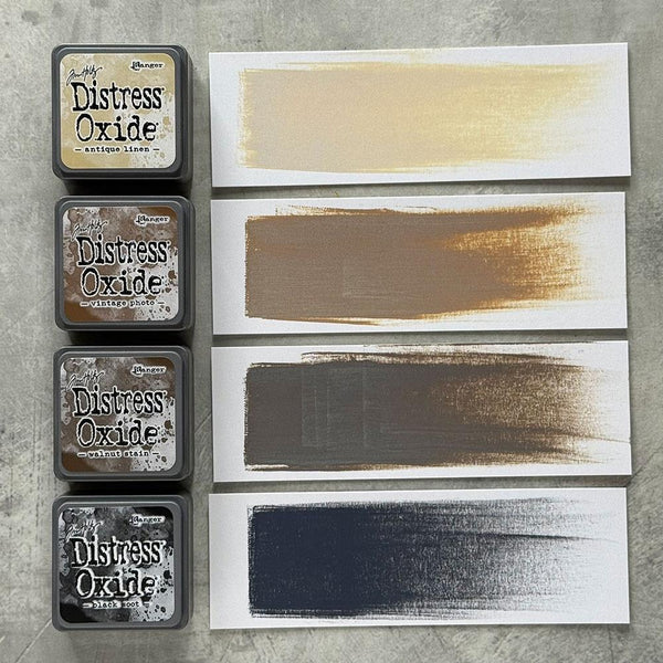 Distress Oxide ink pads with color swatches on a gray surface