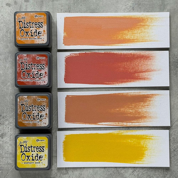 Distress Oxide ink pads with color swatches on a gray surface