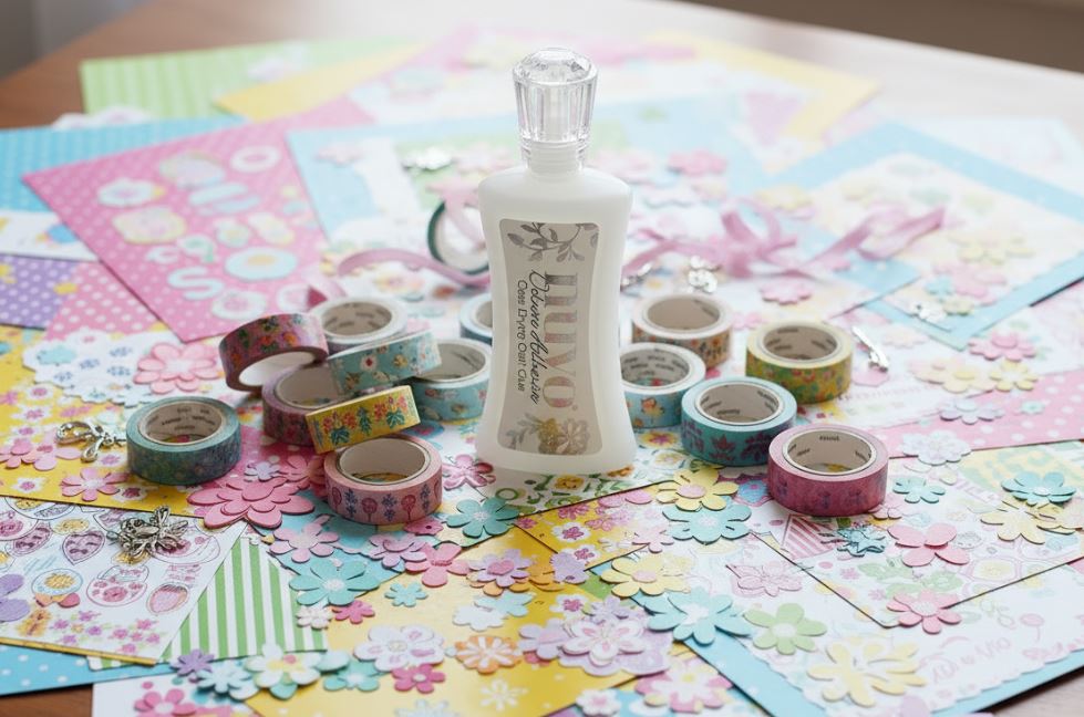 Nuvo Adhesive Decorative tape rolls and a bottle on a colorful paper craft project